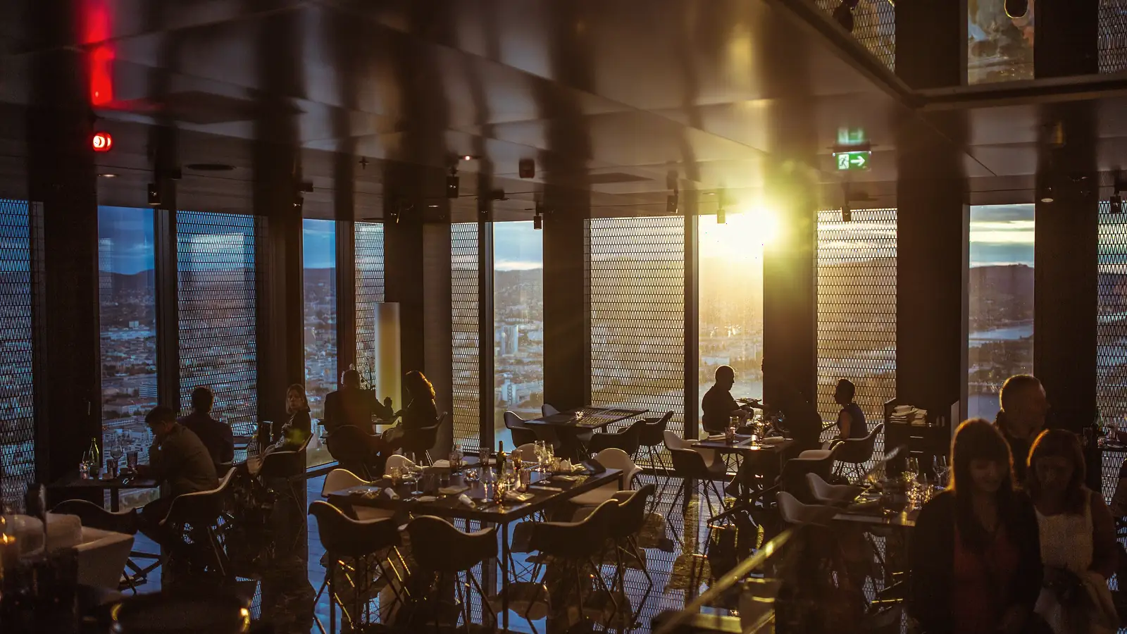 A full restaurant at night, warm light through tall windows